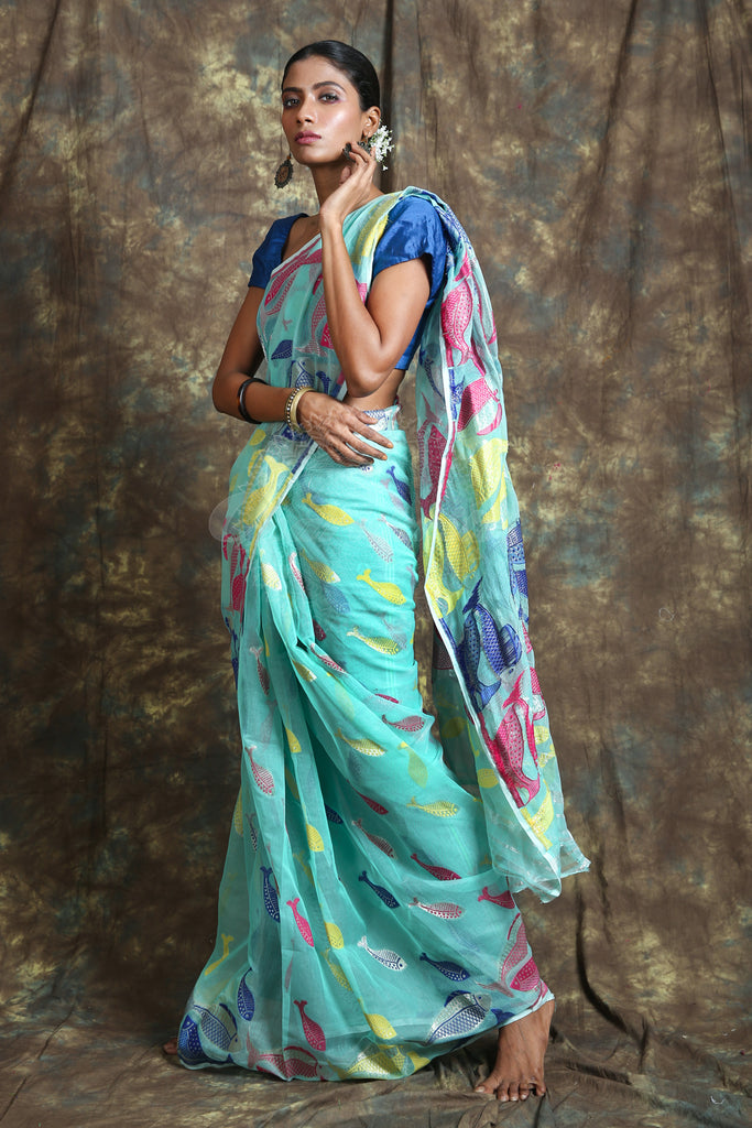 The aquamarine color saree is crafted with multicolor fish motif work all over the body And Pallu - Charukriti.co.in