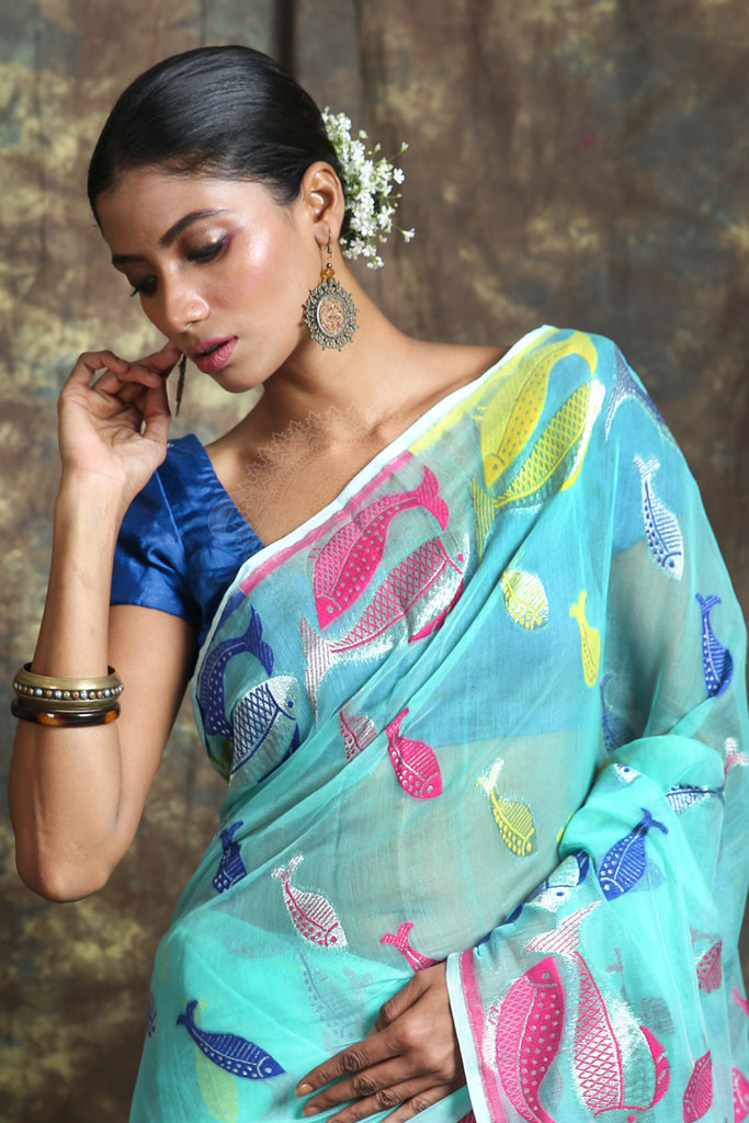 The aquamarine color saree is crafted with multicolor fish motif work all over the body And Pallu - Charukriti.co.in